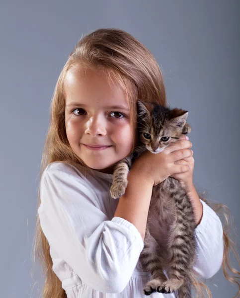 Очаровательная маленькая девочка и ее котенок — стоковое фото