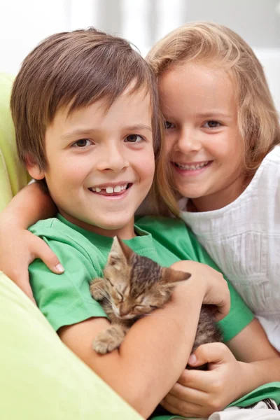 Mutlu çocuklar ile onların yeni evde beslenen hayvan - küçük bir kedi yavrusu — Stok fotoğraf