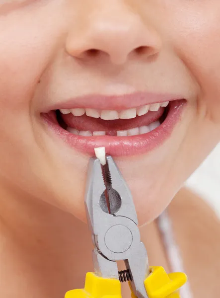 Criança com alicate segurando um dente perdido - close-up — Fotografia de Stock