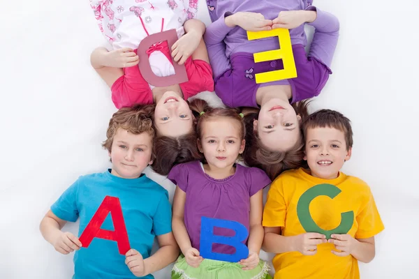 Ομάδα παιδιών που κατέχουν αλφαβητική γράμματα — Φωτογραφία Αρχείου