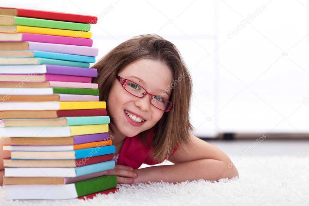 Young student with lots of books smiling