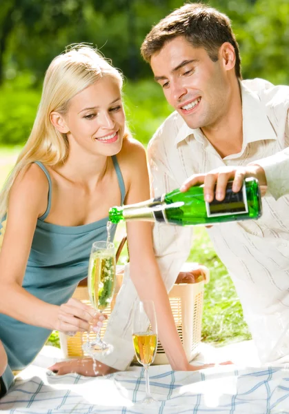 Jovem casal feliz com champanhe, ao ar livre — Fotografia de Stock