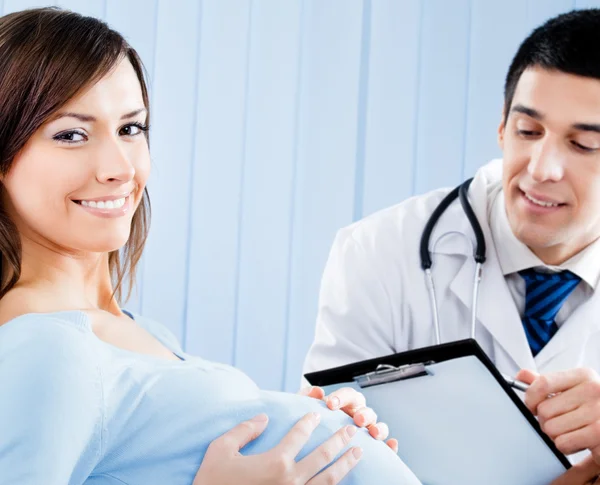 Médico y mujer embarazada con receta en el consultorio —  Fotos de Stock