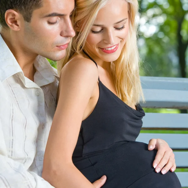 Unga gravid kvinna med man utomhus Royaltyfria Stockfoton