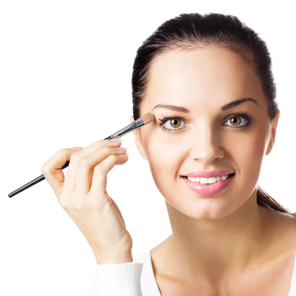 Smiling woman applying eye shadow, by visage brush, isolated — Stock Photo, Image