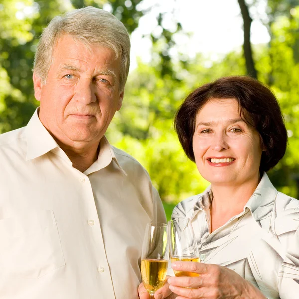 Starszy para obchodzi z szampanem, na zewnątrz — Zdjęcie stockowe