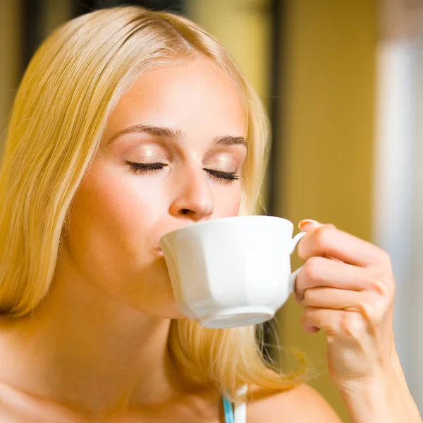Νεαρή γυναίκα πίνοντας καφέ ή τσάι, στο σπίτι — Φωτογραφία Αρχείου