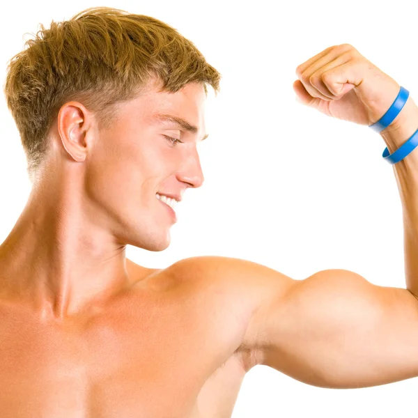 Glada leende ung man visar biceps, isolerade — Stockfoto