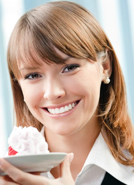 Uśmiechnięta kobieta z ciastem w urzędzie — Zdjęcie stockowe