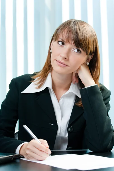 Young thinking businesswoman at office — Stock Photo, Image