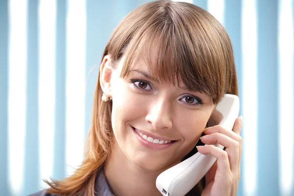 Junge Geschäftsfrau mit Telefon im Büro — Stockfoto