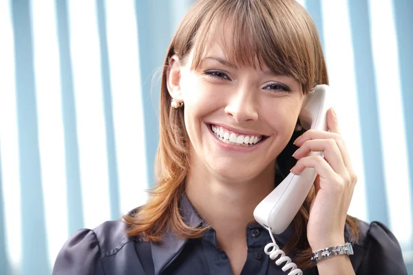 Giovane donna d'affari con telefono in ufficio — Foto Stock