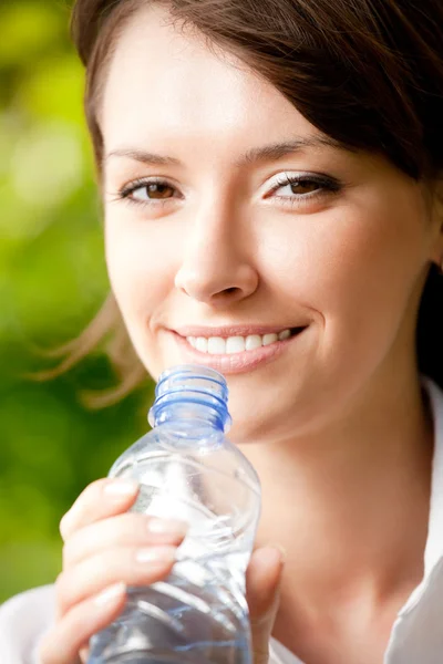 stock image Young attractive woman with bottle of water outdoors