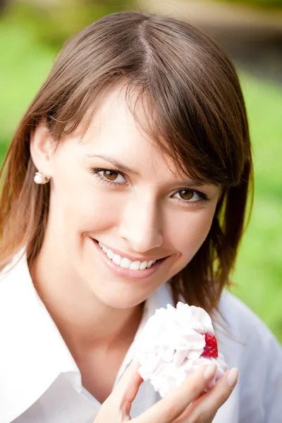 Porträtt av ung kvinna med tårta utomhus — Stockfoto