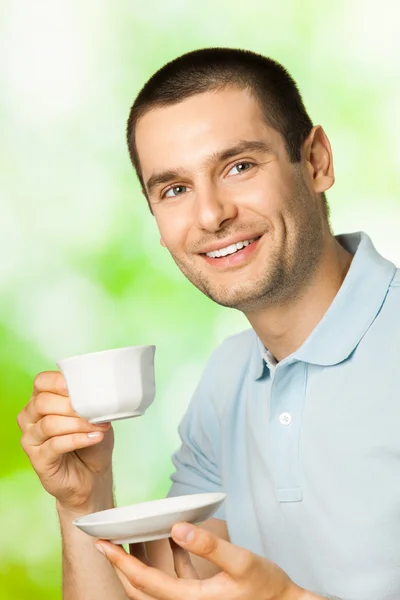Lycklig leende man dricker kaffe, utomhus — Stockfoto