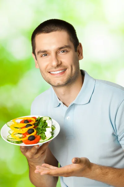 Feliz homem sorridente com prato de salada, ao ar livre — Fotografia de Stock