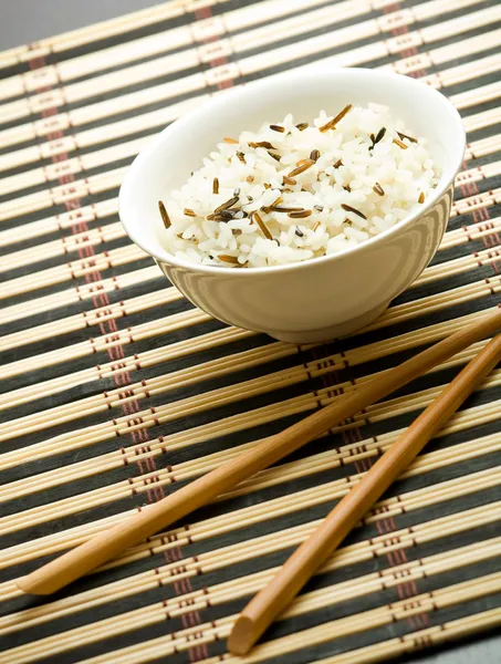 Тарелка с рисом и палочками — стоковое фото