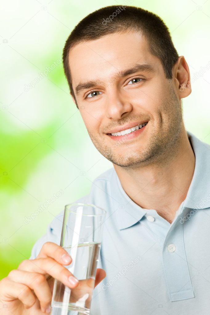 Happy man with glass of water, outdoors