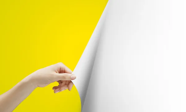 Hand vänder gul sida — Stockfoto