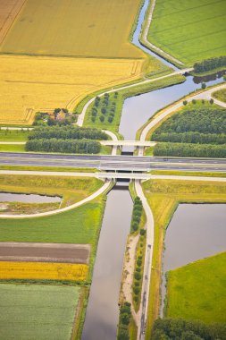 Dutch farm landscape with infrastructure road and canal clipart