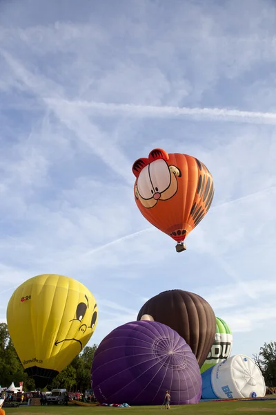 BARNEVELD, THE NETHERLANDS - 17 AUGUST 2012: Colorful Garfield and other air balloons taking off at international balloon festival Ballonfiesta in Barneveld on August 17 in Barneveld, The Netherlands — Stock Photo, Image