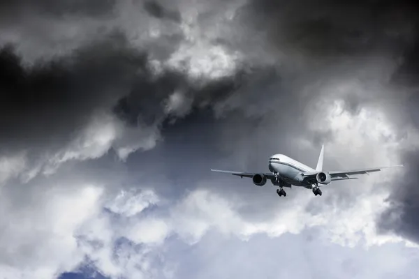 Samolot leciał nad chmury dramatyczne — Zdjęcie stockowe