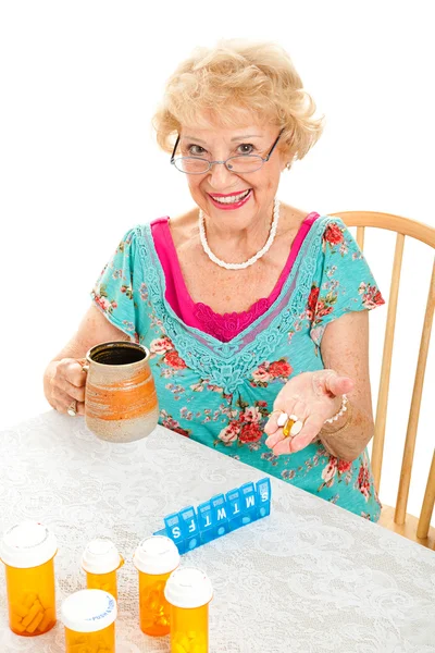Lachende senior vrouw neemt geneeskunde — Stockfoto