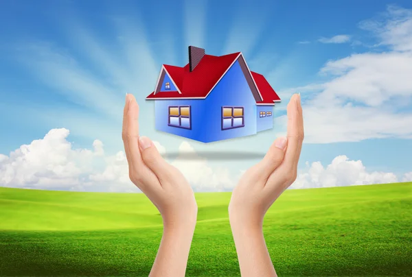 La casa en las manos contra el cielo azul como símbolo del negocio inmobiliario —  Fotos de Stock