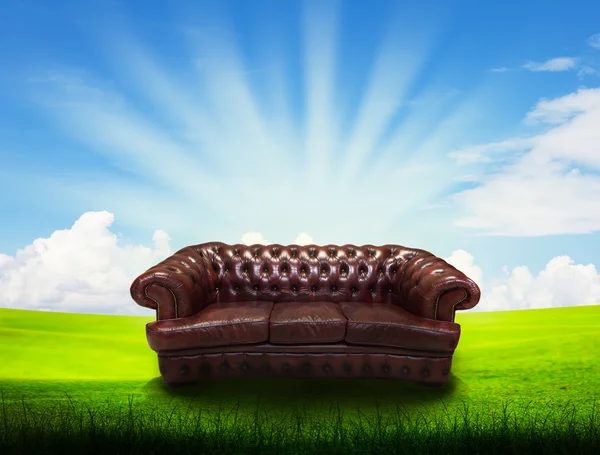 Sozinho sofá no campo de grama — Fotografia de Stock