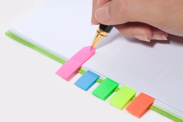 Ręka pisać zakładka na notebooka — Zdjęcie stockowe