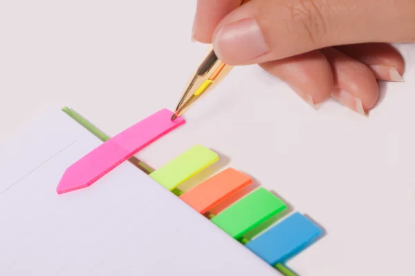Female hand writing bookmark on notebook — Stock Photo, Image