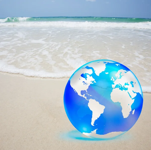 Crystal globe op zand en zee — Stockfoto