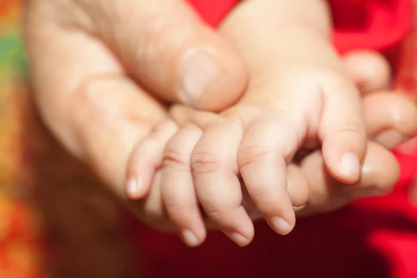 Grandmom hand holding her infant hand — Stock Photo, Image