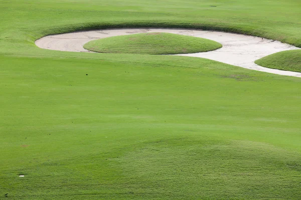Зеленая трава и песок на поле для гольфа — стоковое фото
