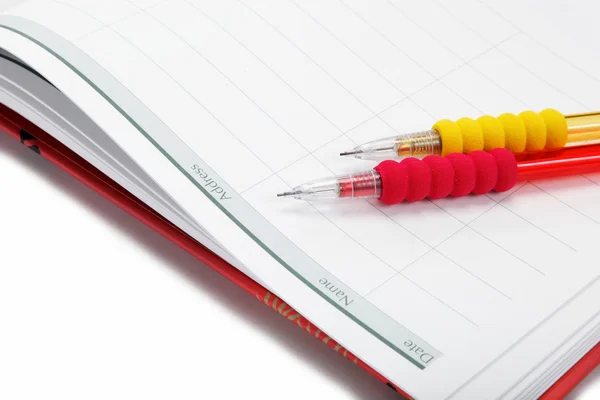 Dva automatické tužky v deníku na bílém pozadí. — Stock fotografie