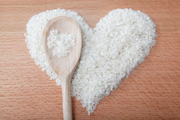 Coração de arroz colocado em uma mesa de madeira . — Fotografia de Stock