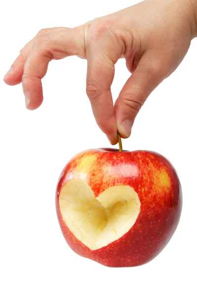 A mão da mulher com a maçã, que cortou o coração em uma parte traseira branca — Fotografia de Stock