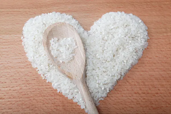 Coração de arroz colocado em uma mesa de madeira . — Fotografia de Stock
