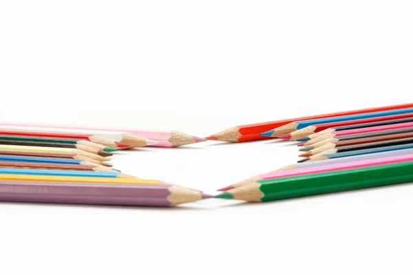 Lápices de colores crayones compuestos en forma de corazón — Foto de Stock