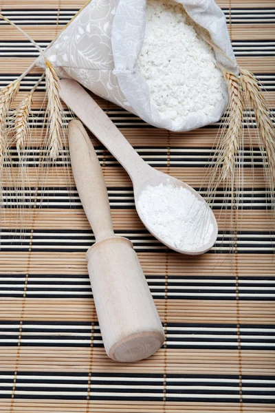 Mehl und Weizenkorn mit Holzlöffel auf einem Holztisch. — Stockfoto
