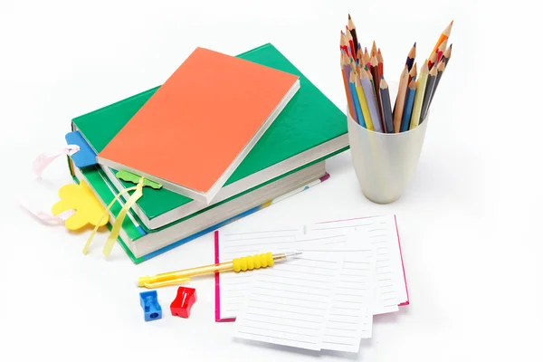 Material escolar: libros, cuadernos, bolígrafos, lápices, sobre una espalda blanca —  Fotos de Stock