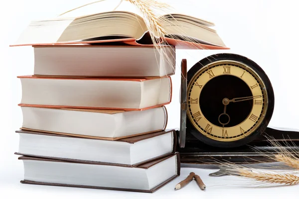 アンティーク時計、白い背景に、書籍のスタック. — ストック写真