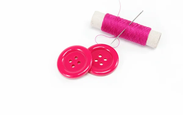 Reel of thread with a needle and buttons on a white background. — Stock Photo, Image