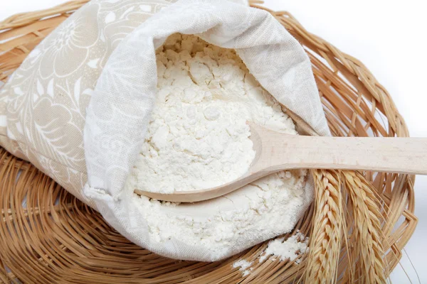 Flour and wheat grain with wooden spoon on a wicker basket. — Stock Photo, Image