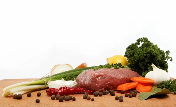 Raw meat, vegetables and spices isolated on a wooden table. — Stock Photo, Image