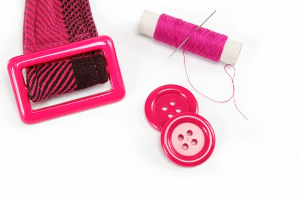 Reel of thread with a needle, buttons and a belt on a white back — Stock Photo, Image