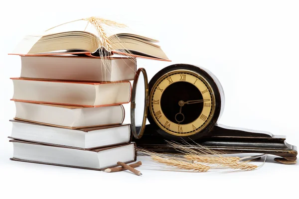 Una pila di libri e orologio antico su sfondo bianco . — Foto Stock