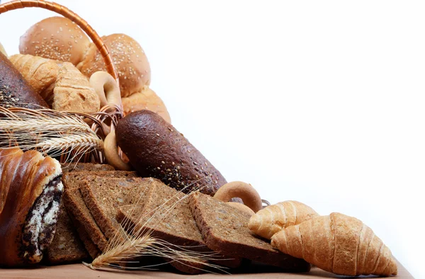 Grande variedade de pão, ainda vida isolada em uma mesa de madeira ove — Fotografia de Stock