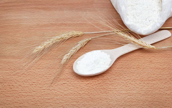 Flour in wooden spoon on a wooden table. — Stock Photo, Image