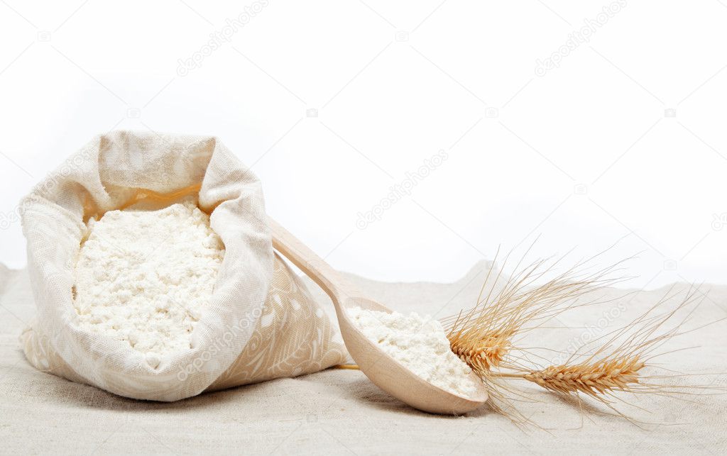 Flour and wheat grain on sackcloth over white